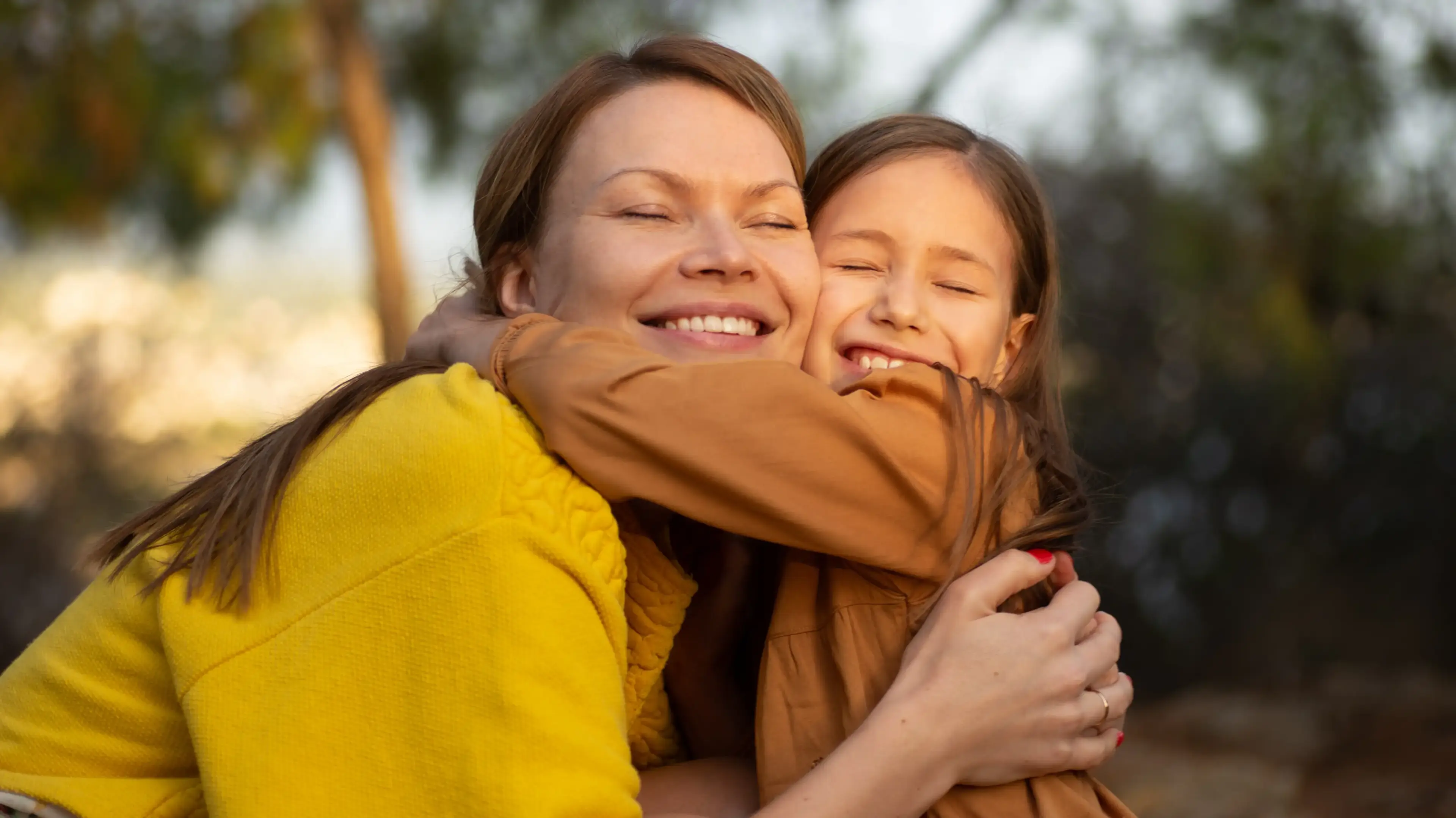 A parent and child sharing a warm hug outdoors